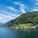 A Norwegian fjord with lush, forested mountains and a dock near the shore